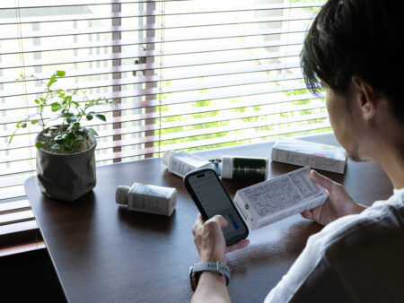 サプリの成分をスマホで調べる男性